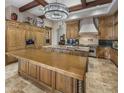 Gourmet kitchen featuring custom wood cabinets, granite countertops, a large center island and designer lighting at 6305 E Arabian Way, Paradise Valley, AZ 85253