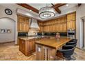 Gourmet kitchen features custom wood cabinets, granite countertops, island, and stainless steel appliances at 6305 E Arabian Way, Paradise Valley, AZ 85253