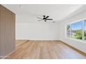Bright living room featuring hardwood floors, a stylish accent wall, and a large window showcasing the neighborhood at 6420 S Wilson St, Tempe, AZ 85283