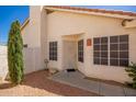 Front entrance featuring a security door, window and desert landscaping at 7603 W Oraibi Dr, Glendale, AZ 85308