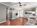 Comfortable living room with hardwood floors, stylish ceiling fan, and access to other areas at 11122 W Desert Butte Dr, Sun City, AZ 85351