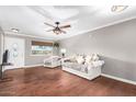 Spacious living room featuring wood floors, a ceiling fan, and a bright window view at 11122 W Desert Butte Dr, Sun City, AZ 85351