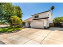 Charming two-story home boasts a well-maintained lawn, mature trees, and a two-car garage at 1353 W Kiowa Ave, Mesa, AZ 85202