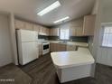 Efficient kitchen with white appliances, light wood cabinets, and a convenient breakfast bar at 18026 N Cave Creek Rd # 140, Phoenix, AZ 85032