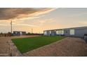 Spacious backyard with gravel, artificial turf, and a storage shed at sunset at 2242 E 12Th Ave, Apache Junction, AZ 85119