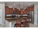 The kitchen features an island with pendant lighting, granite counters, and stainless steel appliances at 22574 W Moonlight Path, Buckeye, AZ 85326