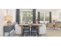 Bright dining room features a modern table with chairs and decor, bathed in natural light from large windows at 23433 W Burton Ave, Buckeye, AZ 85326