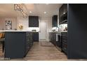 Well-lit kitchen with stainless appliances, dark cabinetry, island, and wood-look flooring for a modern aesthetic at 236 E Minton Dr, Tempe, AZ 85282