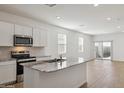 Modern kitchen with granite countertops, stainless steel appliances, and white cabinets at 25471 W Fraktur Rd, Buckeye, AZ 85326