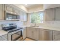 Updated kitchen features stainless steel appliances, gray cabinets, subway tile backsplash and light countertops at 3811 S Mill Ave, Tempe, AZ 85282