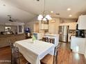 Bright kitchen with white cabinets, stainless steel appliances, and eat-in dining area at 45499 W Sky Ln, Maricopa, AZ 85139