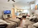 Spacious living room featuring a large sofa, wood floors, and open-concept design at 45499 W Sky Ln, Maricopa, AZ 85139