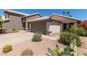 Beautiful exterior view featuring an attached two-car garage, desert landscaping, and charming curb appeal at 5018 W Wikieup Ln, Glendale, AZ 85308