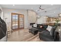 A cozy living room featuring a brick fireplace, hardwood floors, and sliding glass doors at 718 E Devon Dr, Gilbert, AZ 85296