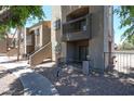 Apartment building with balconies and stucco exterior, accented with lush greenery at 747 S Extension Rd # 115, Mesa, AZ 85210
