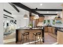 Modern kitchen with island, black marble counters, wooden cabinets, and stainless steel appliances at 908 W Pershing Ave, Phoenix, AZ 85029