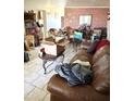 Living room featuring a brick wall, leather sofa, and tile flooring at 1231 E Avila Ave, Casa Grande, AZ 85122