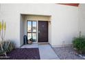 Inviting condo entrance with desert landscaping, decorative welcome decor, and secure wrought iron door at 1401 E Puget Ave # 24, Phoenix, AZ 85020