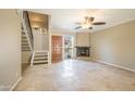 Bright living room with stone flooring, fireplace, ceiling fan, and staircase to the upper level at 1401 E Puget Ave # 24, Phoenix, AZ 85020