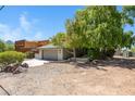 View of the exterior featuring two car garage with concrete driveway, mature landscaping and architectural features at 1419 E Las Palmaritas Dr, Phoenix, AZ 85020