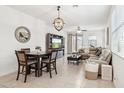 Bright living and dining space with tiled floors, a modern ceiling fan, and neutral decor at 14360 W Pershing St, Surprise, AZ 85379