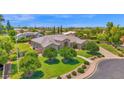 Beautifully landscaped front yard showcasing mature trees, manicured lawn, and a charming walkway to the home's entrance at 1940 N Stevens Cir, Mesa, AZ 85205
