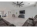 Open-concept living room with expansive tile flooring, stylish furniture, and a large TV at 20109 W Madison St, Buckeye, AZ 85326