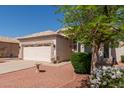 Charming single-story home features a two-car garage, desert landscaping, and a beige exterior at 20632 N 103Rd Ave, Peoria, AZ 85382