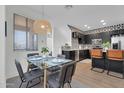 Bright dining area features a modern glass table, stylish chairs, and a decorative pendant light at 240 W Juniper Ave # 1020, Gilbert, AZ 85233