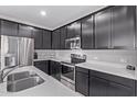 A well-appointed kitchen with dark wood cabinetry, stainless appliances and quartz countertops at 2625 S Peppertree Dr # 101, Gilbert, AZ 85295