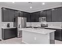 This kitchen features dark wood cabinetry, stainless appliances and a kitchen island with a double sink at 2625 S Peppertree Dr # 101, Gilbert, AZ 85295