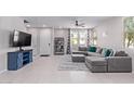 Comfortable living room with a large grey sectional, a ceiling fan, and views from the large windows at 2625 S Peppertree Dr # 101, Gilbert, AZ 85295