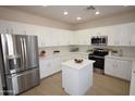Bright kitchen with white cabinets, stainless steel appliances, granite countertops, and a center island at 28377 N Desert Native St, San Tan Valley, AZ 85143