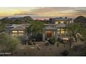 Desert home exterior boasts unique architecture, mature trees and desert landscape views at sunset at 28729 N 107Th St, Scottsdale, AZ 85262