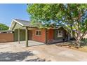 Home featuring a covered parking area with additional driveway space and brick siding at 3538 W Sierra Vista Dr, Phoenix, AZ 85019