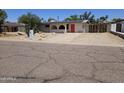 Street view of a single-story home with desert landscaping and a bright red front door at 4110 E Wagoner Rd, Phoenix, AZ 85032