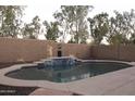 Private backyard pool with tiled accents, a water feature, and ample space for outdoor relaxation at 4145 E Santa Fe Ln, Gilbert, AZ 85297