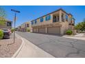 Modern townhome exterior featuring attached garages and vibrant blue shutters and convenient parking at 4705 E Red Oak Ln # 101, Gilbert, AZ 85297