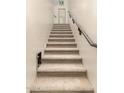 A staircase leading up to the next floor with carpeted steps and dark wood railing at 4705 E Red Oak Ln # 101, Gilbert, AZ 85297