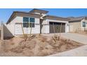 Charming single-Gathering home featuring a two-car garage, desert landscaping, and a modern blue front door at 5566 S 254Th Gln, Buckeye, AZ 85326