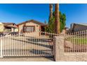 Charming single-story home featuring a well-kept yard and secure front gate at 5649 W Holly St, Phoenix, AZ 85035