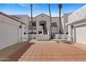 Exterior of the white condo featuring a red brick driveway and a stairway leading up to the front door at 6138 N 28Th St, Phoenix, AZ 85016