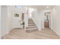 Inviting foyer with a staircase, bright white walls and light wood-look flooring at 6439 E Redmont Dr, Mesa, AZ 85215