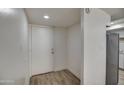 Bright entryway featuring a white door, wood-look floors, and stainless steel appliances visible from the kitchen at 7920 E Camelback Rd # 609, Scottsdale, AZ 85251