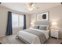 This bedroom has a ceiling fan, large windows with white shutters and blue curtains at 9212 W Salter Dr, Peoria, AZ 85382
