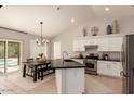 Bright kitchen with stainless steel appliances, a black island, and sliding door access to the backyard pool area at 9212 W Salter Dr, Peoria, AZ 85382
