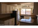 Bright kitchen featuring white cabinetry, stainless steel appliances, and a window overlooking the backyard at 10326 W Harmont Dr, Peoria, AZ 85345