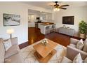 Open-concept living room featuring hardwood floors, neutral furniture, and an open kitchen layout at 1048 E 6Th Ave, Mesa, AZ 85204