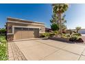 A clean, concrete driveway leading to the garage with brick-lined edges and desert landscaping on either side at 1087 Leisure World --, Mesa, AZ 85206