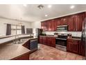 Well-equipped kitchen featuring stainless steel appliances and rich wood cabinetry for a modern culinary experience at 1120 E Jahns Dr, Casa Grande, AZ 85122